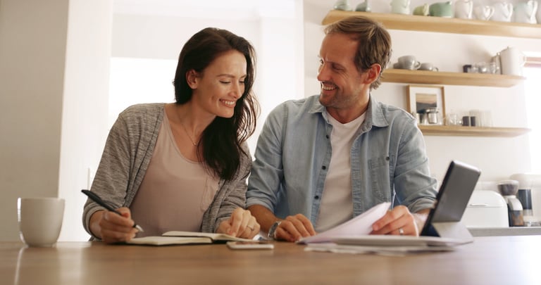 Couple reviewing finances together in kitchen discussing investments