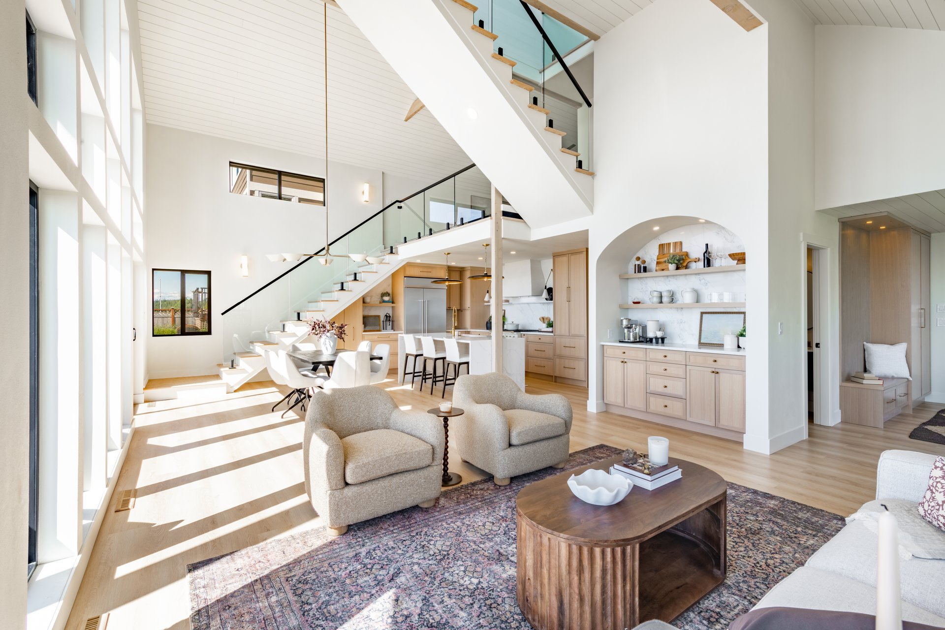 Modern oceanfront home interior with floor to ceiling windows, vaulted ceiling, and elegant living space