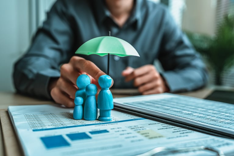 Wooden family figures under an insurance umbrella representing life insurance protection